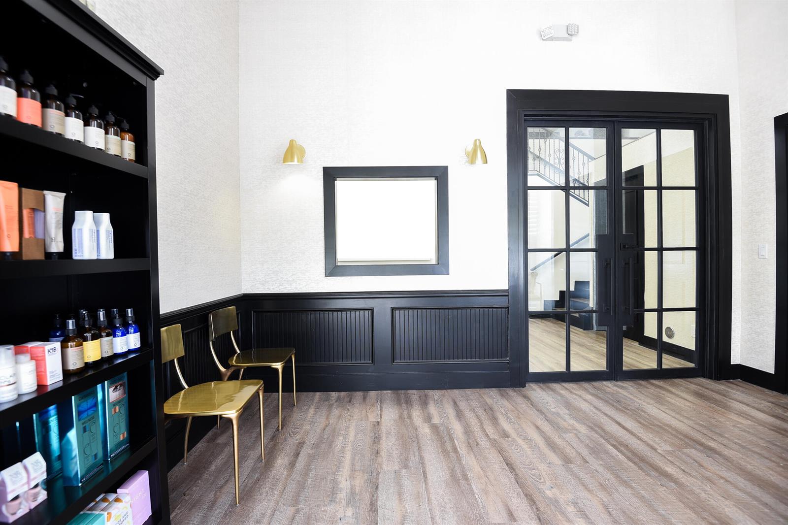 A waiting area features black wainscoting, gold chairs, a black bookshelf, and glass-paned double doors — 900 E Atlantic Avenue # 12, Delray Beach FL 33483, DELRAY BEACH, FL