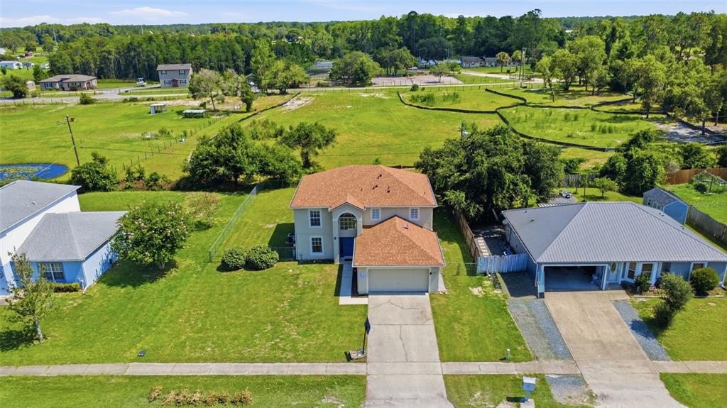An aerial view shows a two-story suburban house with a brown roof and driveway — 2678 BECKWITH STREET, DELTONA, FL