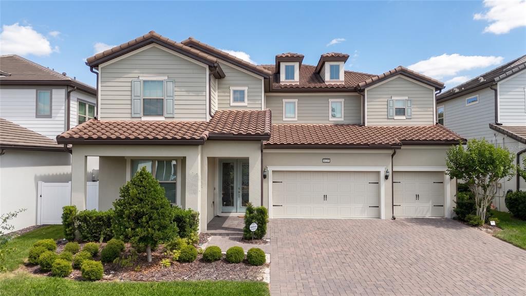 A two-story suburban house with a tiled roof, light siding, and a paved driveway — 8059 LEAF GROVE CIRCLE, ORLANDO, FL