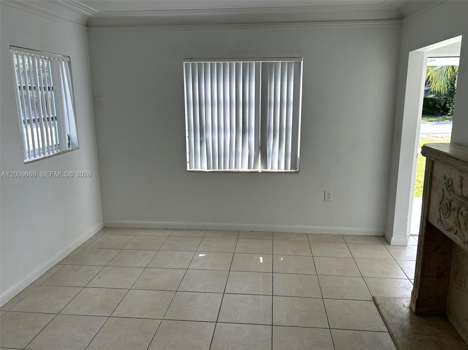 A room with white walls, tiled floors, two windows with vertical blinds, and a doorway — 9808 NW 2nd Ave, Miami FL 33150, MIAMI, FL
