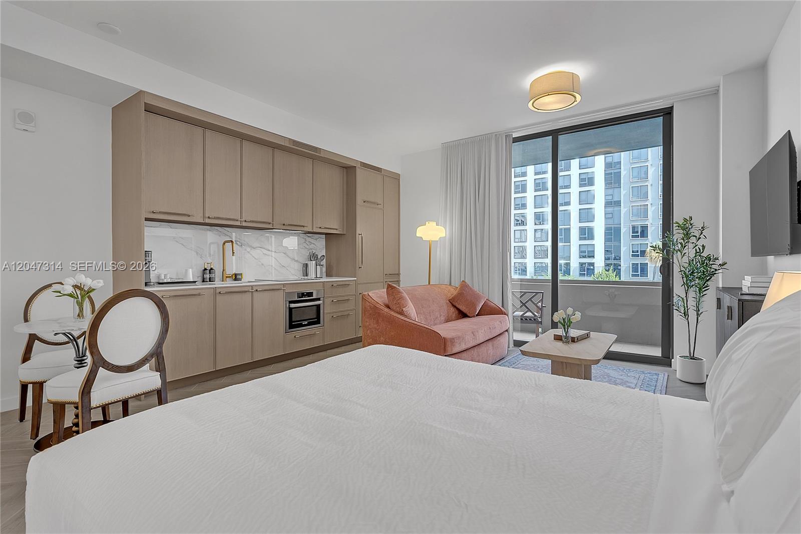 A studio apartment features a kitchenette, a bed, a pink sofa, and a balcony — 2700 NW 2nd Ave # 246, Miami FL 33127, MIAMI, FL