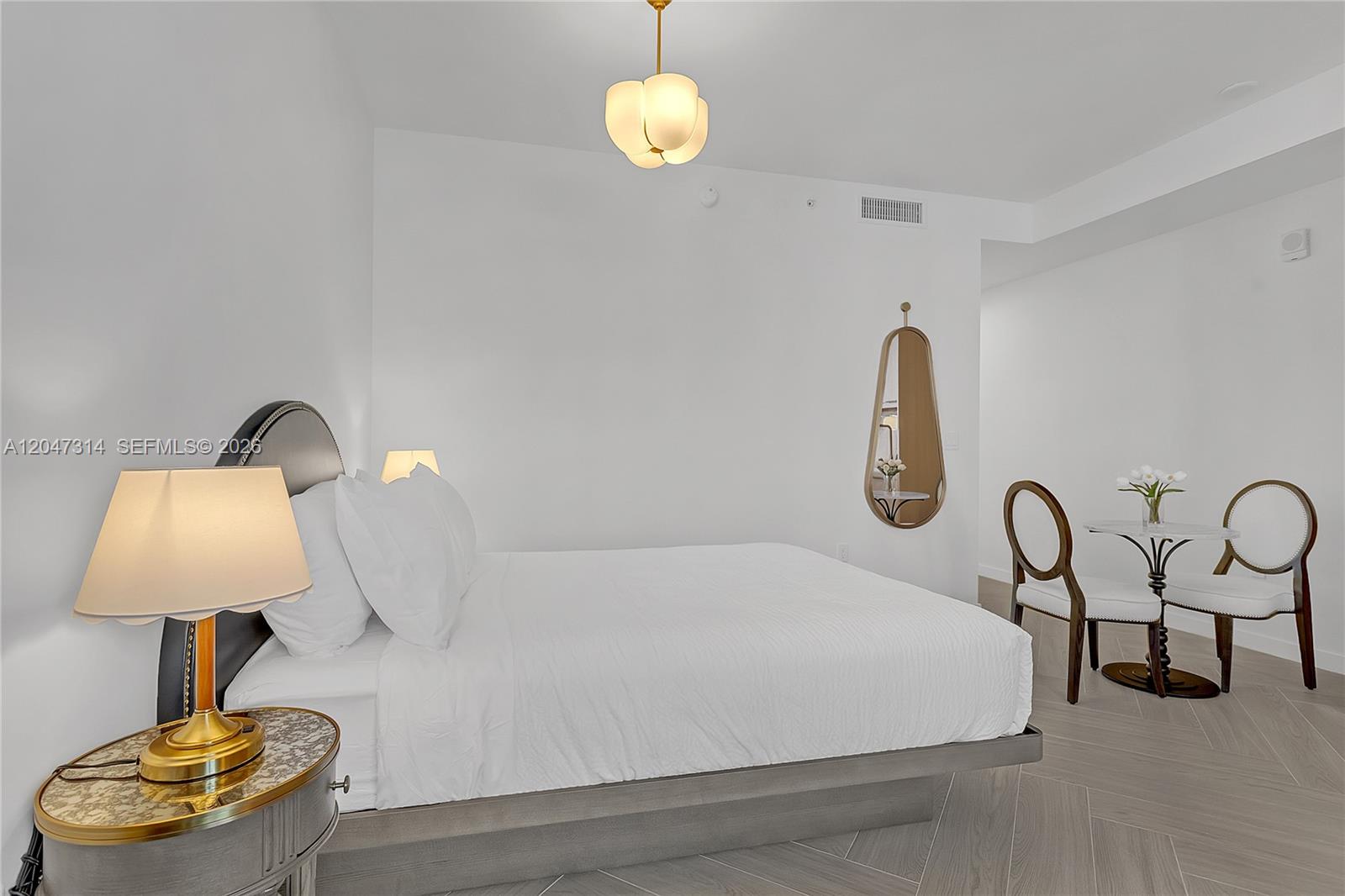 A bedroom features a bed, a small dining table with two chairs, and a mirror — 2700 NW 2nd Ave # 246, Miami FL 33127, MIAMI, FL