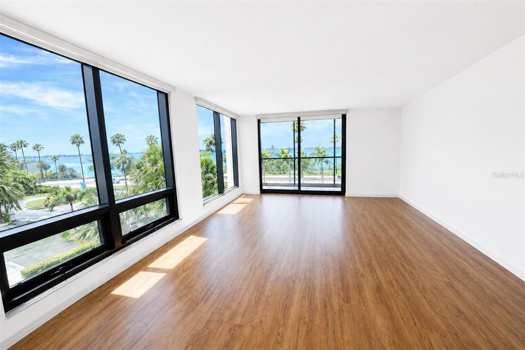 An aerial view shows a coastal city with high-rise buildings, a road, and a bay — 707 S GULFSTREAM AVENUE UNIT 307, SARASOTA, FL