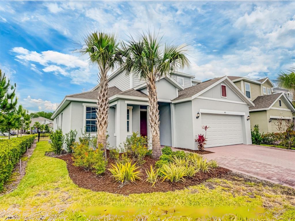 A two-story house with a light gray exterior, a two-car garage, and two palm trees — 603 FORTUNA DRIVE, DAVENPORT, FL