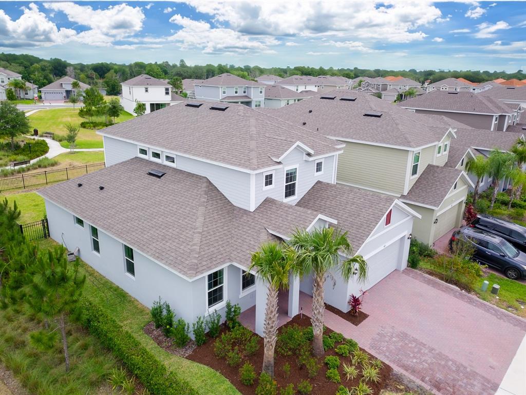 An aerial view of a two-story suburban house with a paved driveway and palm trees — 603 FORTUNA DRIVE, DAVENPORT, FL