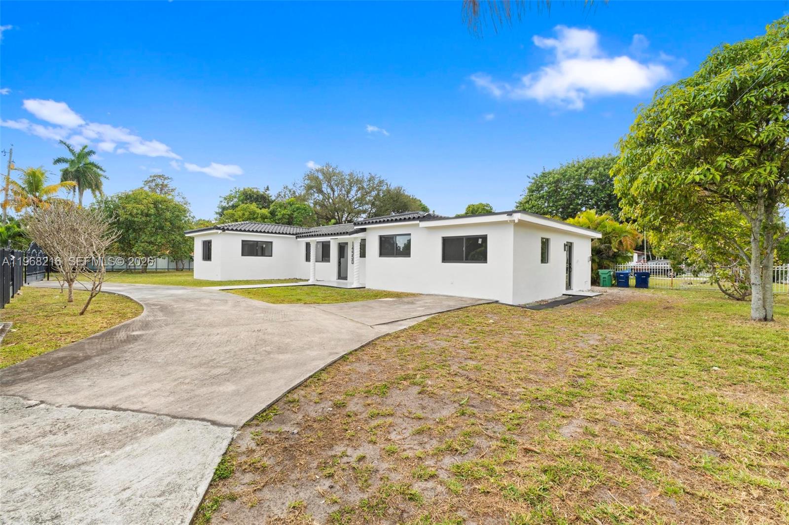 A white, single-story house with a concrete driveway sits on a grassy lot — 14950 NE 2nd Ave, Miami FL 33161, MIAMI, FL