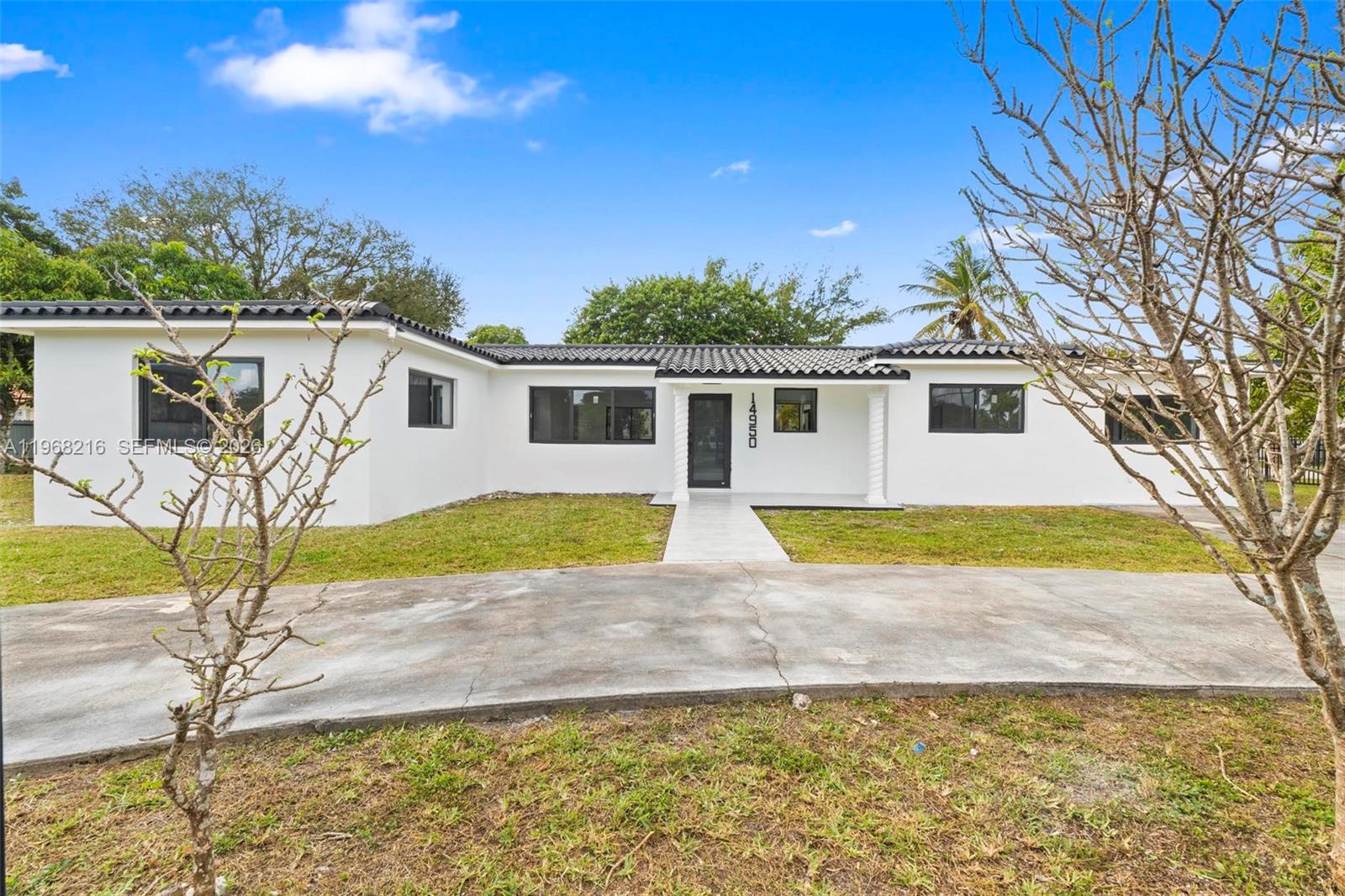A white, single-story house with a dark tiled roof and a concrete driveway — 14950 NE 2nd Ave, Miami FL 33161, MIAMI, FL