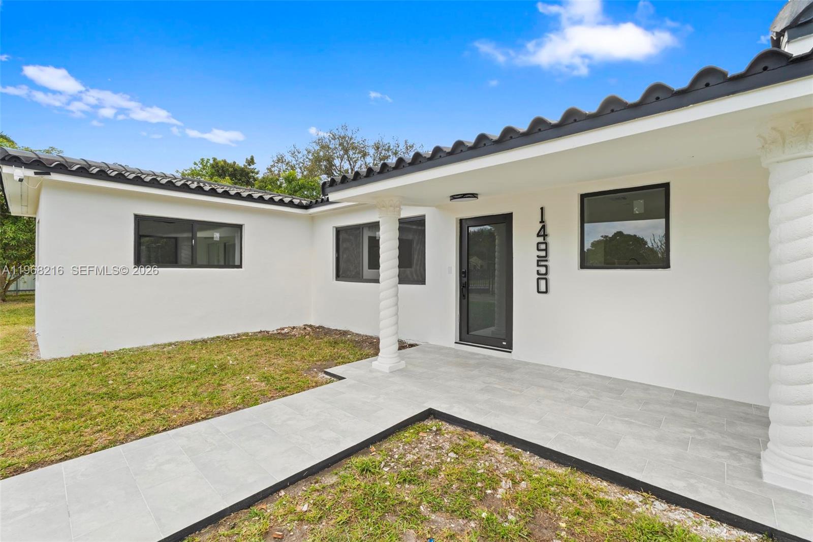 The exterior of a white house features a tiled porch, spiral columns, and a glass door — 14950 NE 2nd Ave, Miami FL 33161, MIAMI, FL