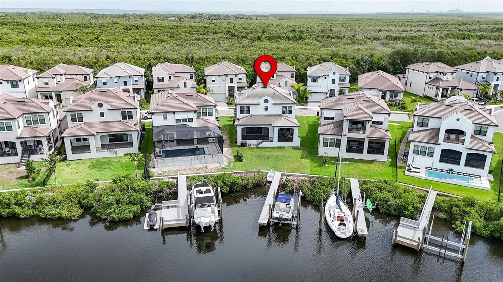 An aerial view shows waterfront houses with private boat docks and a large nature preserve — 1108 SEAGRAPE DRIVE, RUSKIN, FL