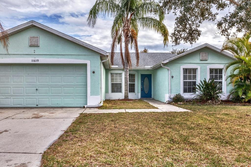 A light green, single-story house with a two-car garage and a blue front door — 11619 SUMMIT ROCK COURT, PARRISH, FL