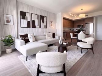 A modern living room with a white sectional sofa, two armchairs, and an open kitchen — 315 NW 27th Ave # 314, Miami FL 33125, MIAMI, FL