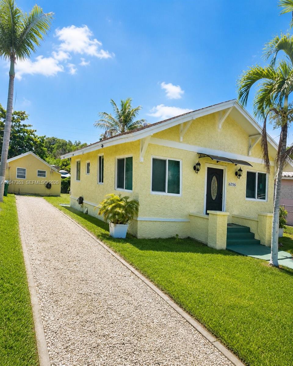 A yellow single-story house with a gravel driveway and palm trees in the front yard — 6926 NW 4th Ave, Miami FL 33150, MIAMI, FL