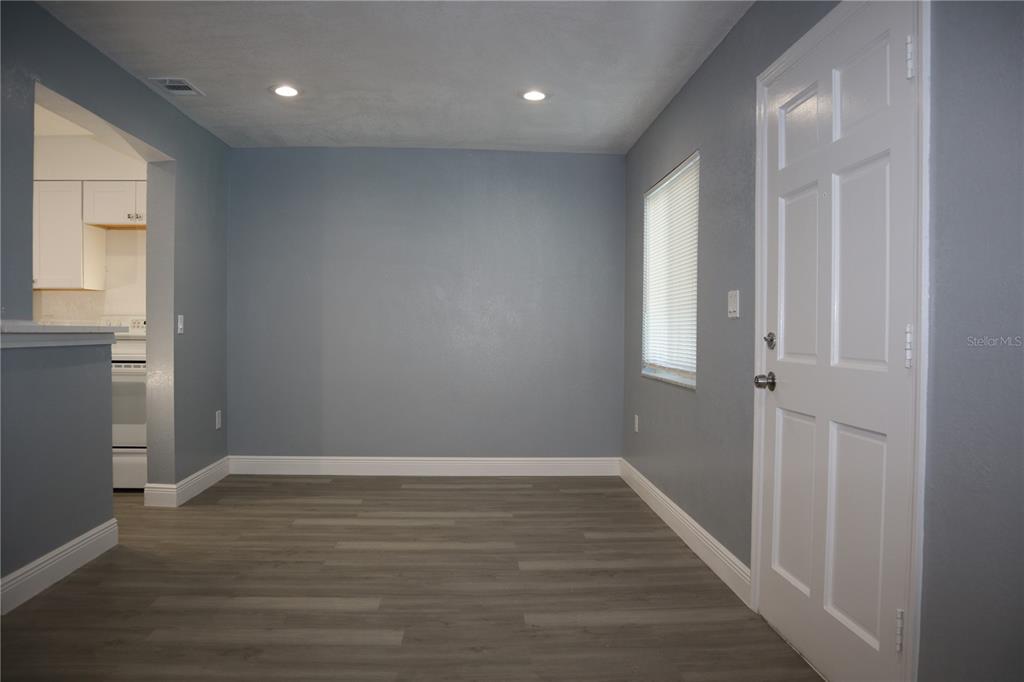 A dining area with gray walls, wood-look flooring, recessed lighting, and a white door — 350 79TH AVENUE N UNIT 236, ST PETERSBURG, FL