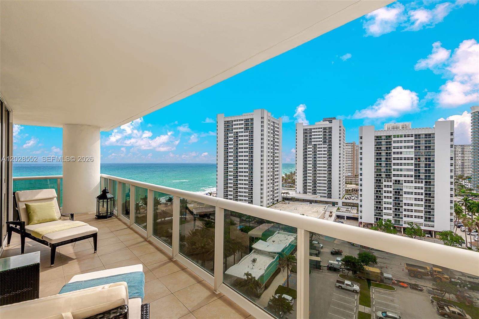 A balcony with outdoor furniture overlooks the ocean and several high-rise apartment buildings — 1850 S Ocean Dr # 1105, Hallandale Beach FL 33009, HALLANDALE BEACH, FL