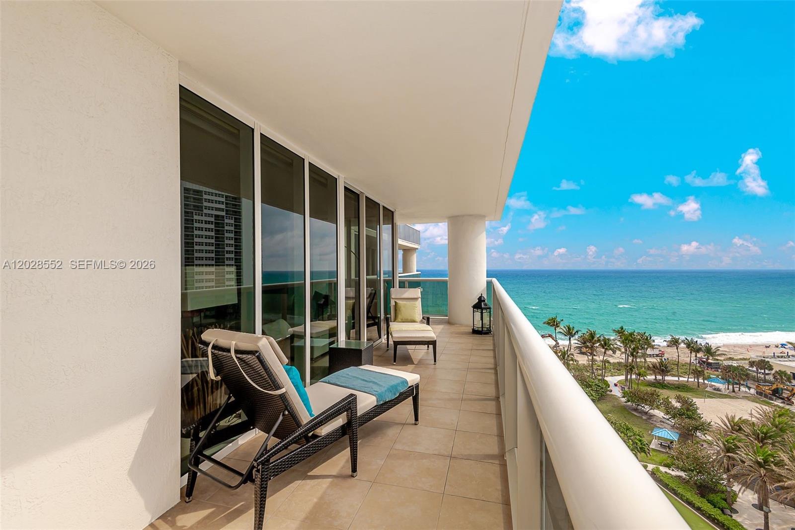 A balcony features two lounge chairs overlooking the ocean and a sandy beach — 1850 S Ocean Dr # 1105, Hallandale Beach FL 33009, HALLANDALE BEACH, FL