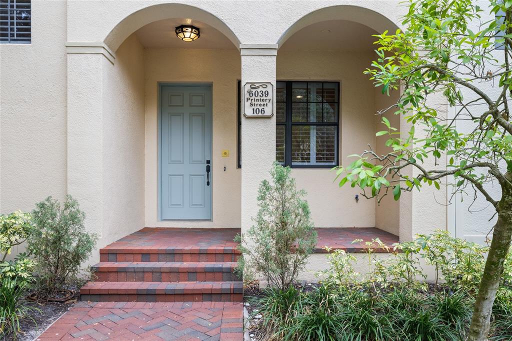 The exterior entrance features a light blue door, brick steps, and a covered porch area — 6039 PRINTERY STREET UNIT 106, TAMPA, FL
