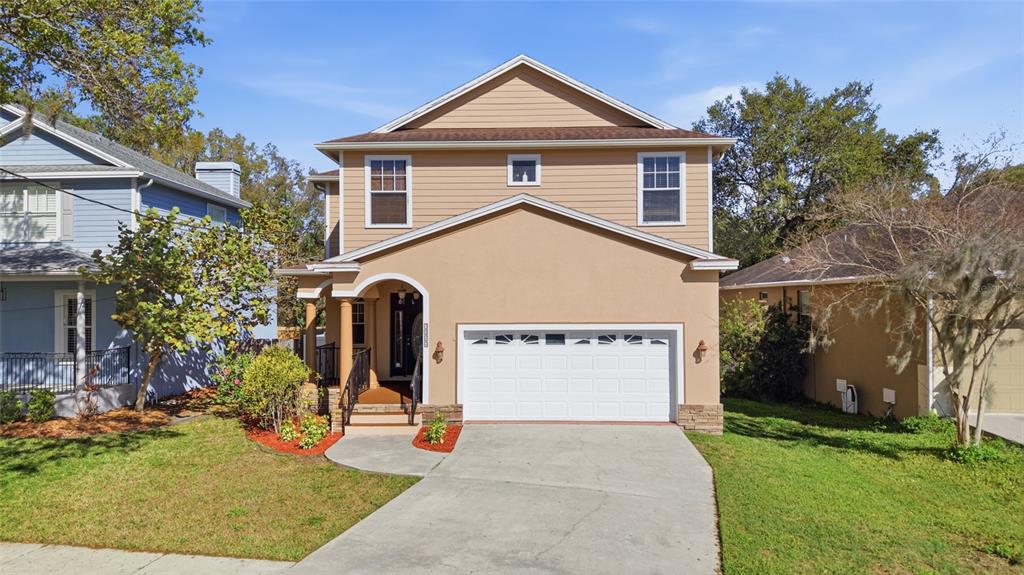 A two-story house with tan siding, a stucco facade, and a two-car garage — 7504 S WEST SHORE BOULEVARD, TAMPA, FL