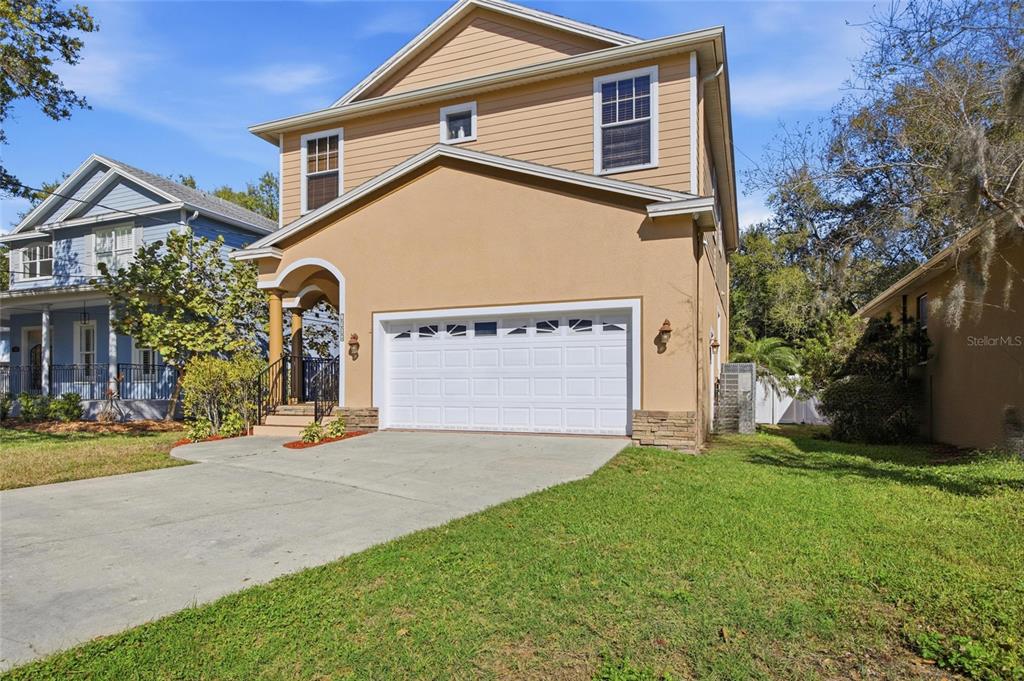 A two-story tan house with a two-car garage and a front porch — 7504 S WEST SHORE BOULEVARD, TAMPA, FL