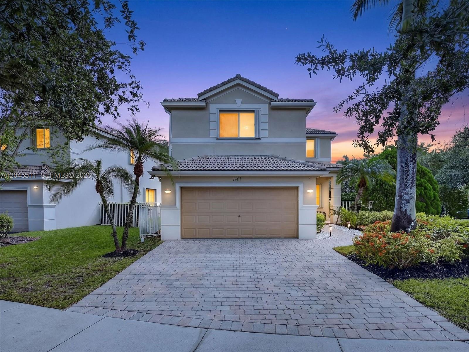 A two-story suburban house features a paved driveway, a two-car garage, and landscaping — 1401 Canary Island Dr, Weston FL 33327, WESTON, FL