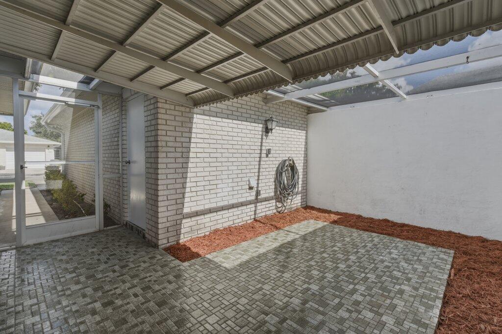 A white brick house exterior features a garage, a walkway, and a screened front entrance — 10098 S 42nd Drive, Boynton Beach FL 33436, BOYNTON BEACH, FL