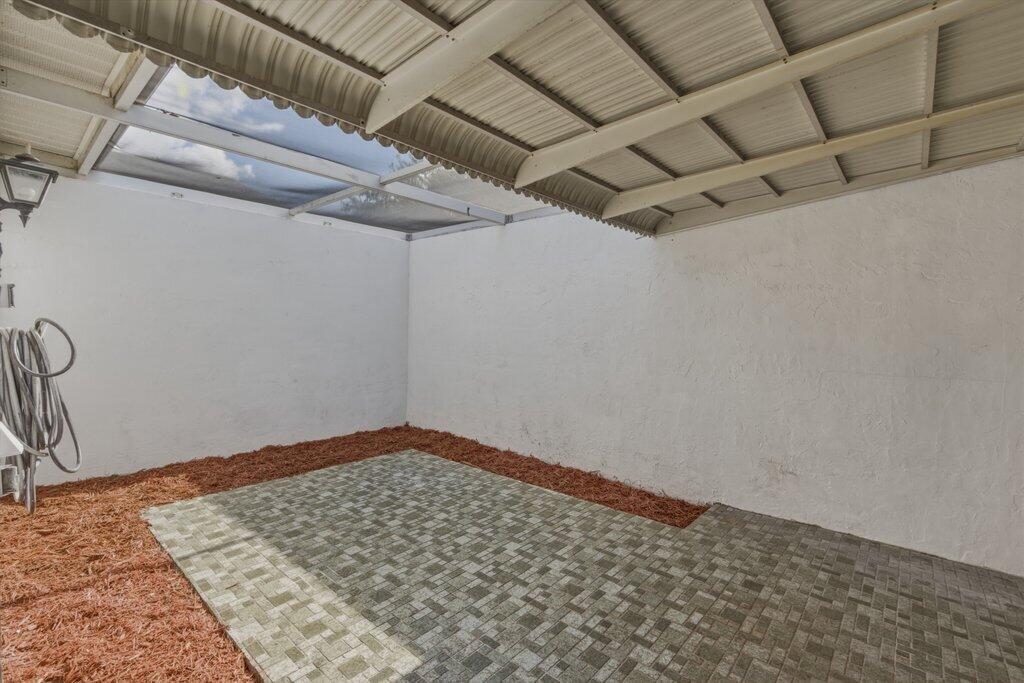 A covered outdoor patio with a paved floor and white walls surrounded by mulch — 10098 S 42nd Drive, Boynton Beach FL 33436, BOYNTON BEACH, FL