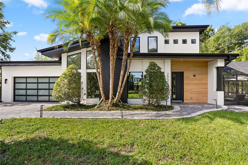 A modern two-story house features a black-and-white exterior, wood siding, and a palm tree — 2032 KIMBRACE PLACE, WINTER PARK, FL