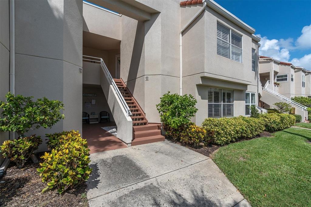 Exterior view of a two-story tan stucco apartment building with an outdoor staircase — 6000 BAHIA DEL MAR CIRCLE UNIT 131, ST PETERSBURG, FL