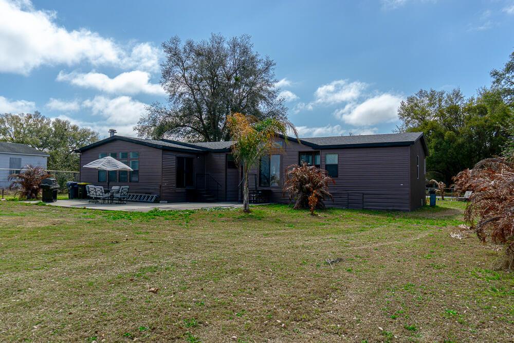 The exterior of a dark brown manufactured home features a patio with outdoor furniture — 5472 Citrus Hill Drive, FL 33868, FL