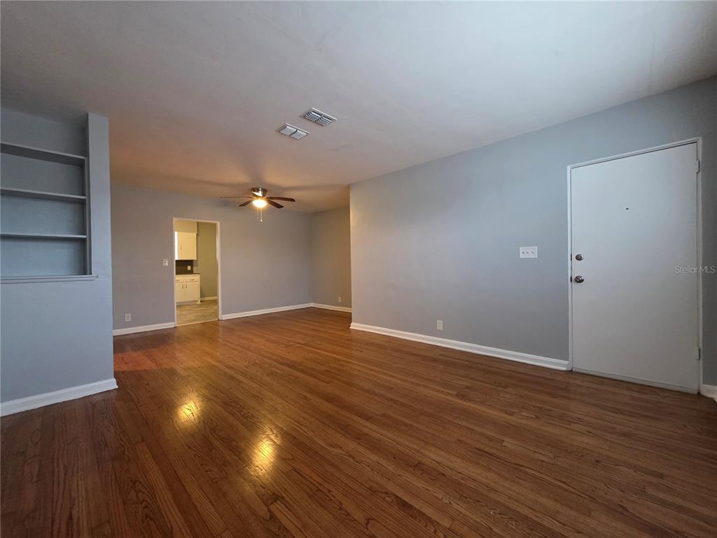 An empty living room features hardwood floors, light gray walls, and a ceiling fan — 3148 BELDEN STREET UNIT 3, JACKSONVILLE, FL