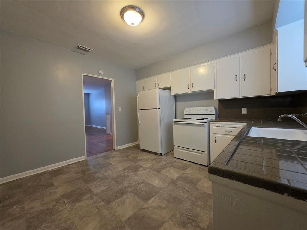 A kitchen with white cabinets, a white refrigerator, a white stove, and tiled countertops — 3148 BELDEN STREET UNIT 3, JACKSONVILLE, FL
