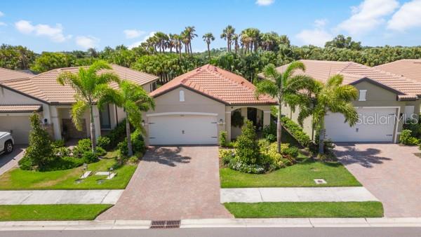 An aerial view shows three suburban houses with tile roofs and paved driveways — 200 SOLIERA STREET, NOKOMIS, FL