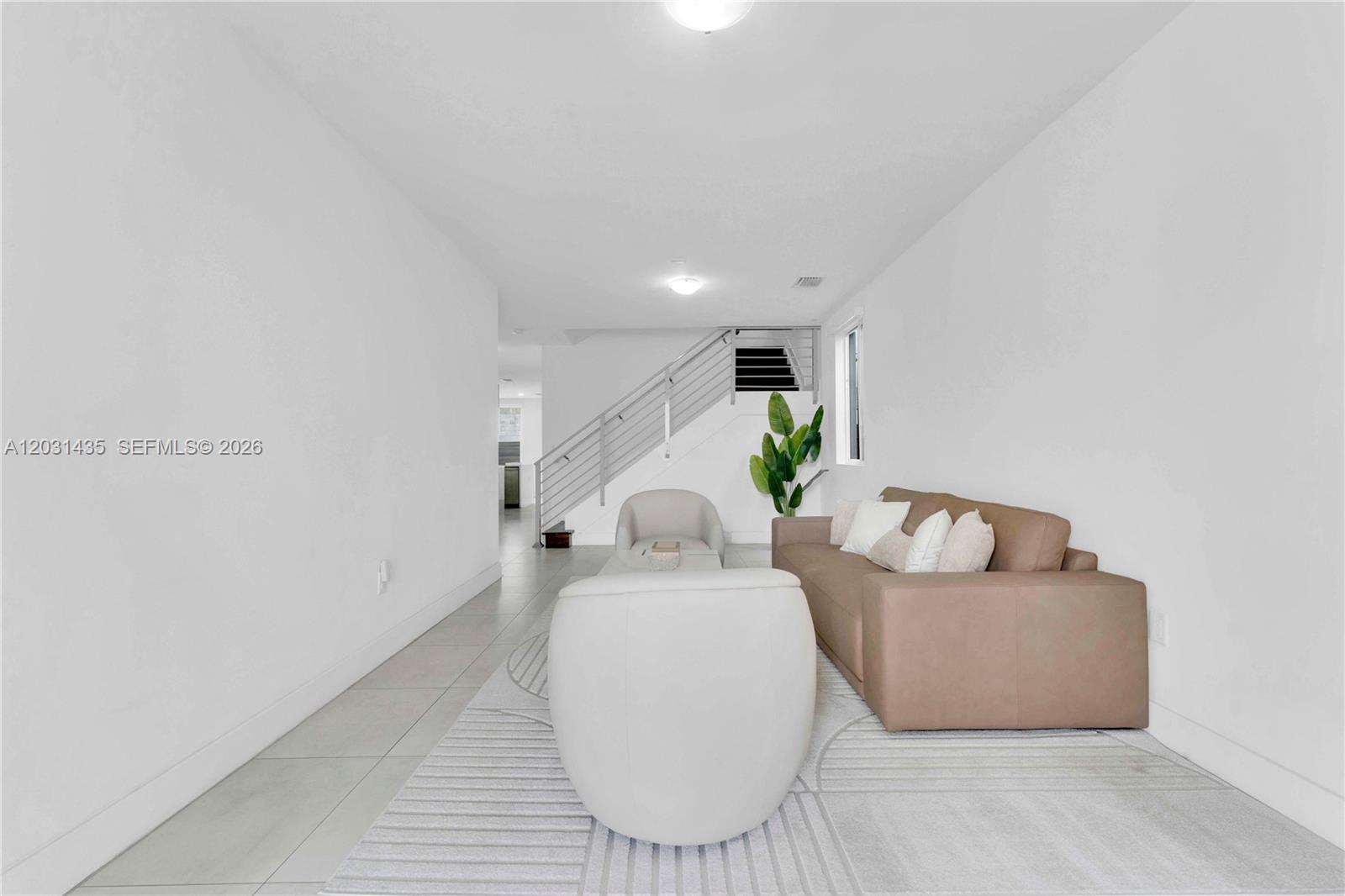 A living room features white walls, tile flooring, a brown sofa, and a staircase — 6750 NW 103rd Ave, Doral FL 33178, DORAL, FL