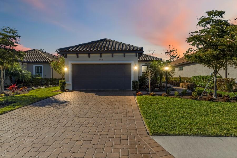 A screened-in patio features a swimming pool, a raised spa, and stone paver decking — 14659 DERNA TERRACE, BRADENTON, FL