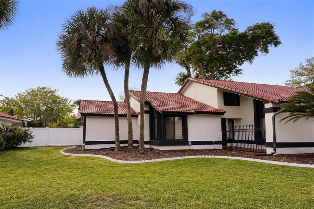 A single-story house with a red tile roof and white walls sits behind a lawn — 249 WATERFORD COURT, ALTAMONTE SPRINGS, FL