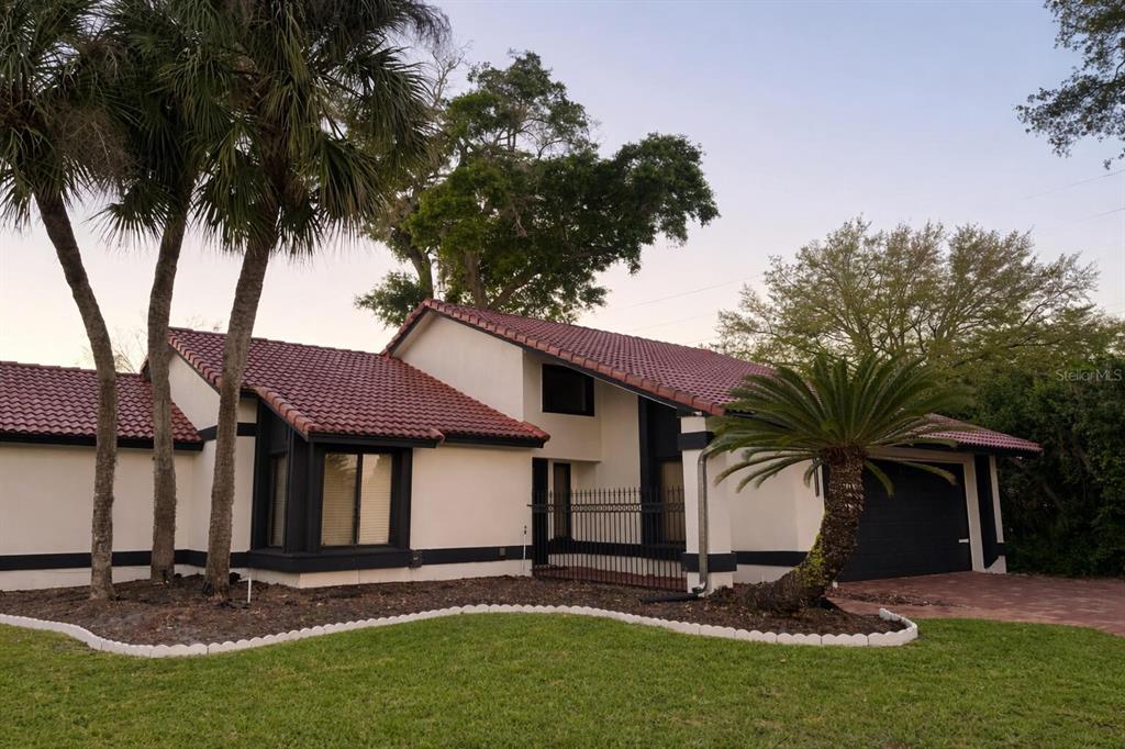 A single-story house with a red tile roof, white stucco walls, and dark trim — 249 WATERFORD COURT, ALTAMONTE SPRINGS, FL