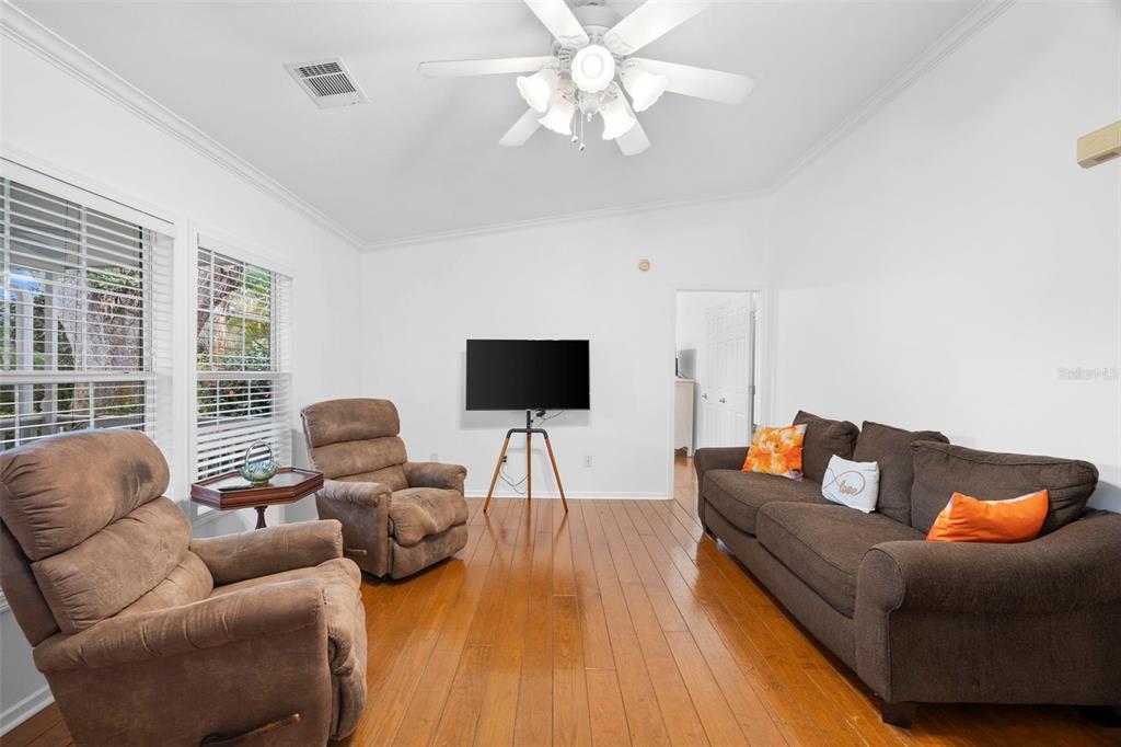 A living room features hardwood floors, a ceiling fan, two recliners, and a brown sofa — 13015 ELM STREET, ODESSA, FL