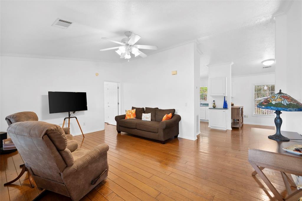 A living room features hardwood floors, a brown sofa, a recliner, and a ceiling fan — 13015 ELM STREET, ODESSA, FL