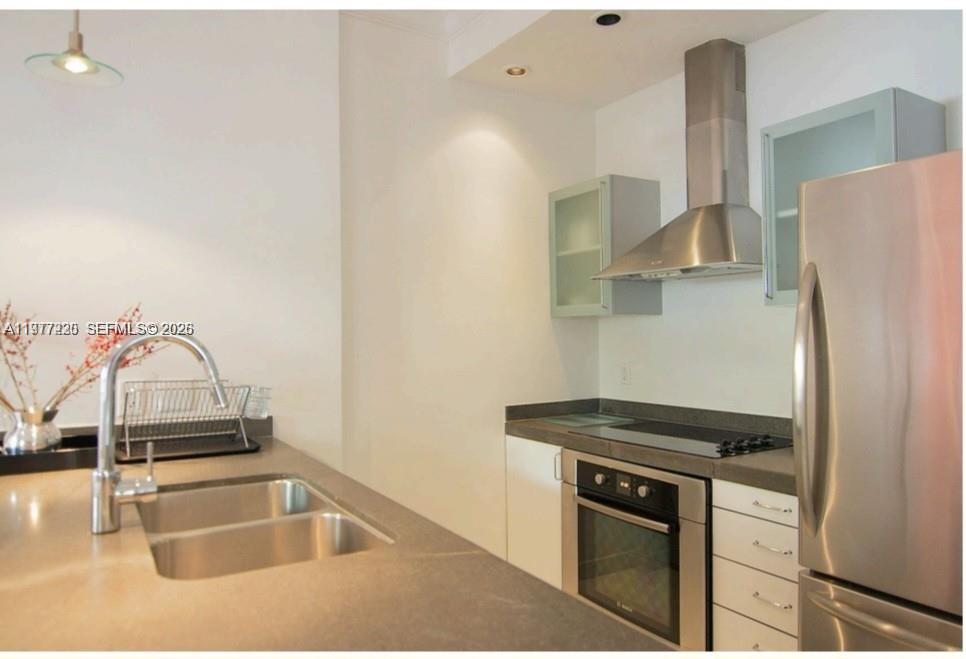 A modern kitchen features stainless steel appliances, grey countertops, and light-colored cabinetry — 130 3rd St # 101, Miami Beach FL 33139, MIAMI BEACH, FL