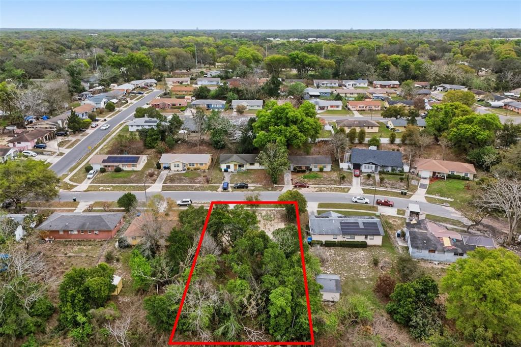 An aerial view shows a vacant, tree-covered residential lot outlined in red — 1670 S CENTRAL AVENUE, APOPKA, FL
