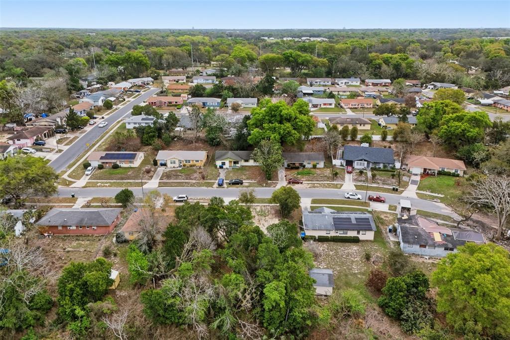 An aerial view shows a residential neighborhood with single-story houses, tree-lined streets, and grassy yards — 1670 S CENTRAL AVENUE, APOPKA, FL