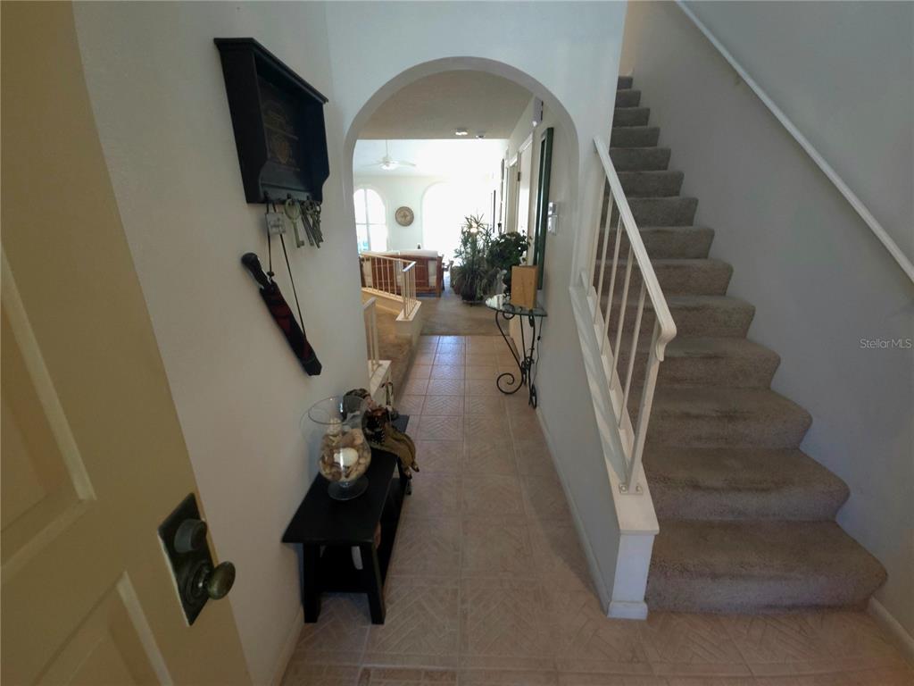 An entryway features a tiled floor, a staircase with carpet, and an arched doorway — 3502 57TH AVE CIR W, BRADENTON, FL