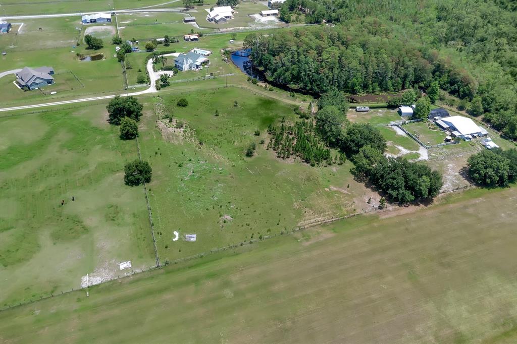 An aerial view shows a large, grassy rural property with scattered trees and several buildings — ALBRITTON ROAD, ST CLOUD, FL