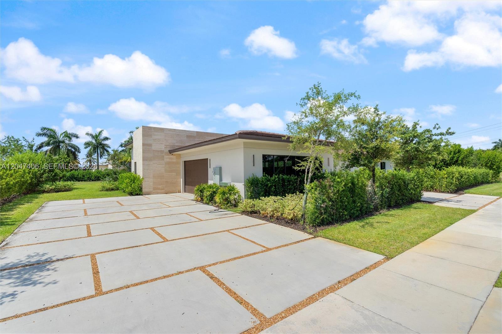 A modern single-story house features a concrete paver driveway and a stone-accented exterior wall — 14930 SW 16th Ct, Davie FL 33326, DAVIE, FL