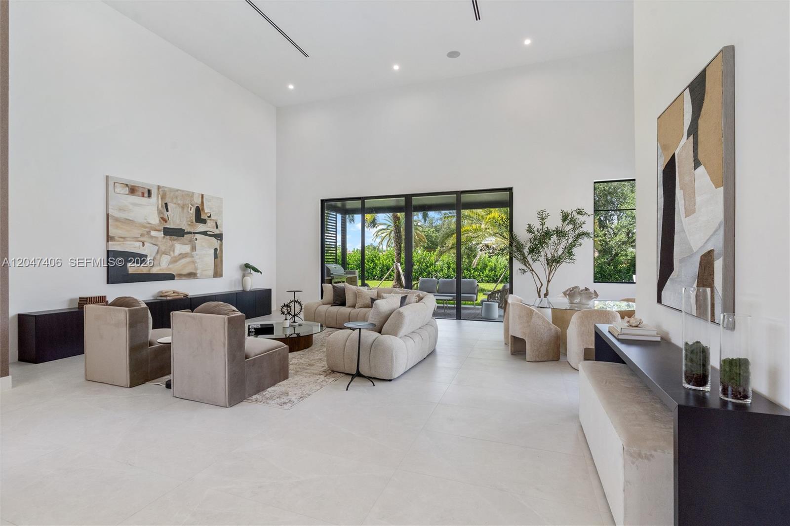 A spacious living room features high ceilings, neutral furniture, and large glass sliding doors — 14930 SW 16th Ct, Davie FL 33326, DAVIE, FL