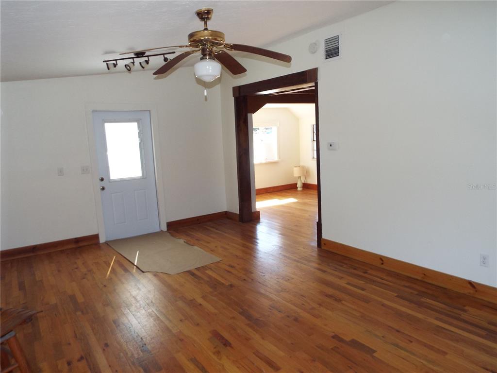 A room with hardwood floors, a ceiling fan, and a doorway leading to another room — 150 E BAY HEIGHTS ROAD, ENGLEWOOD, FL