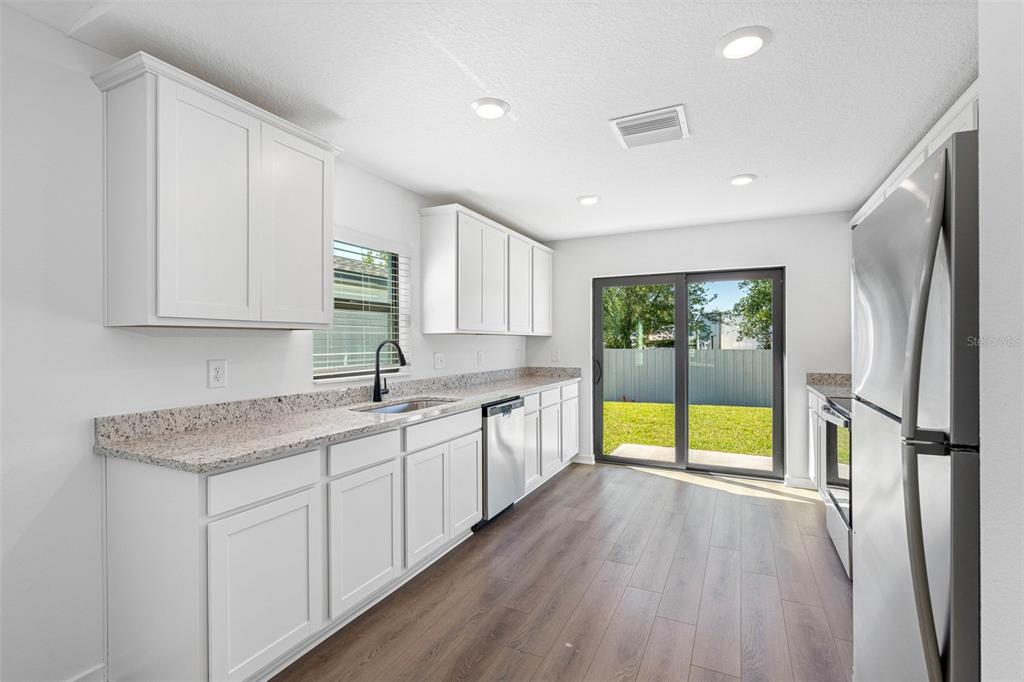 A living room with a beige sofa, green armchair, wood coffee table, and tile flooring — 11308 LINNET ROAD, WEEKI WACHEE, FL