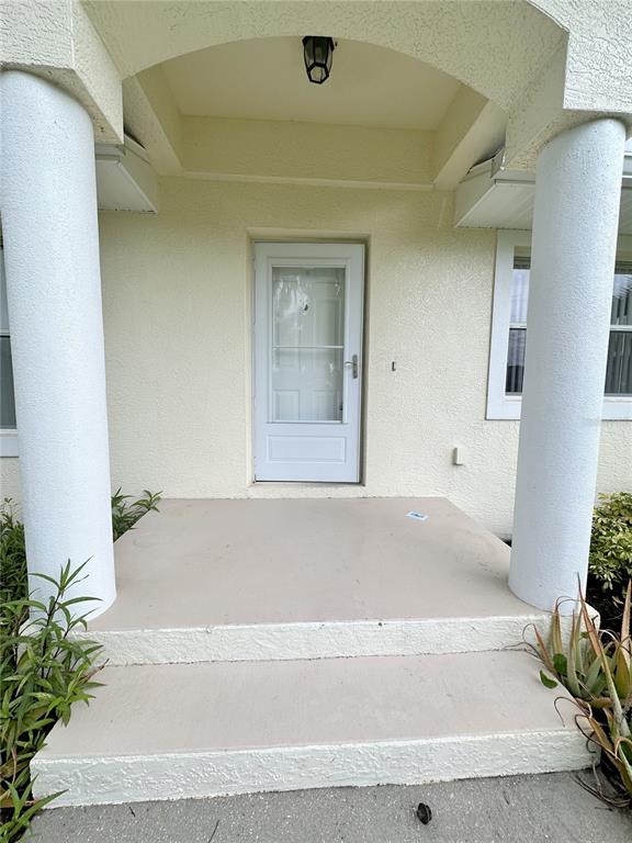A front porch features two white columns, a white door, and concrete steps — 199 ROTONDA BOULEVARD W UNIT C, ROTONDA WEST, FL