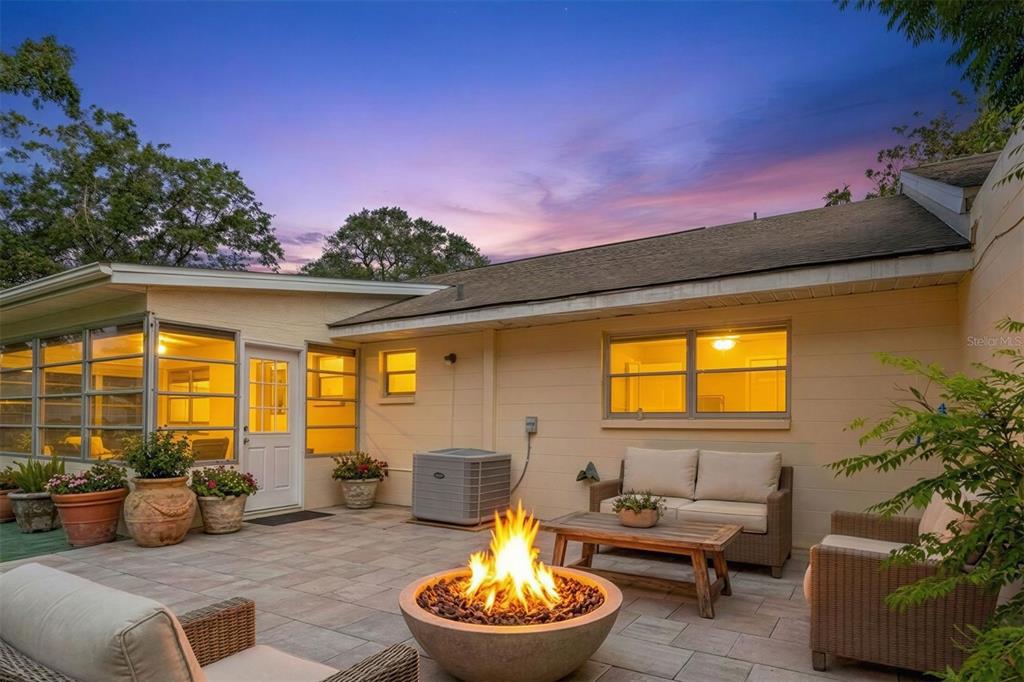 A patio with a fire pit, outdoor seating, and a house exterior at twilight — 8660 SW 94TH STREET UNIT F, OCALA, FL