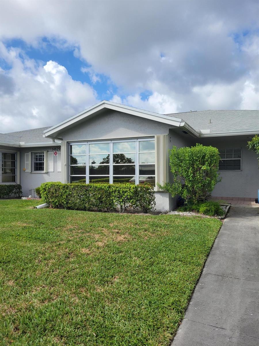 A single-story house exterior features a large front window, a green hedge, and a walkway — 14629 Canalview Drive # C, Delray Beach FL 33484, DELRAY BEACH, FL