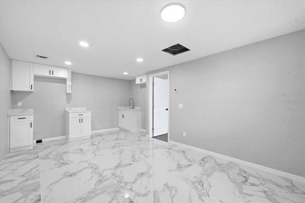 A kitchen area features white cabinets, marble-patterned tile flooring, and light gray walls — 6224 KELLER DRIVE UNIT 2, PORT RICHEY, FL